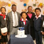 Some primary school graduating pupils with the school's chairman, head teacher and a class teacher.
